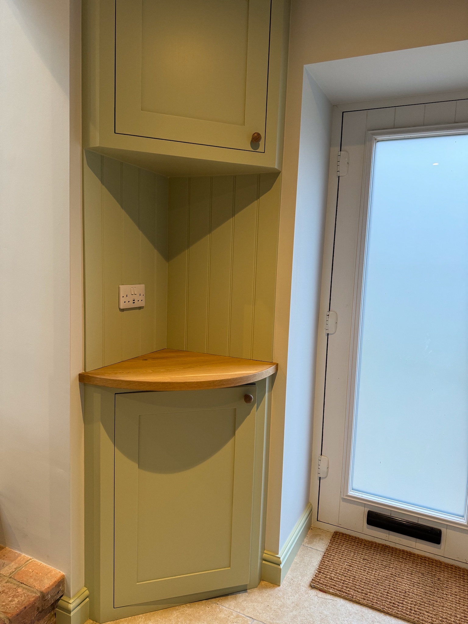 Green hallway storage with oak shelf