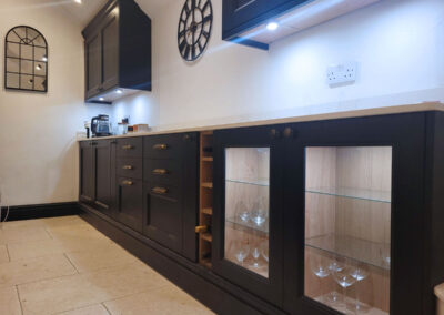 Dark blue kitchen with glassed doors and in cupboard lightening