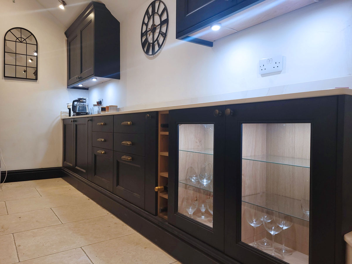 Dark blue kitchen with glassed doors and in cupboard lightening